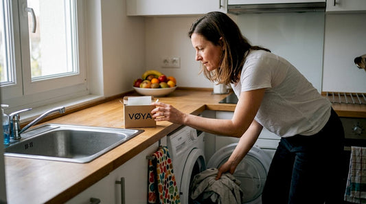Une femme utilise de la lessive compacte dans sa cuisine.